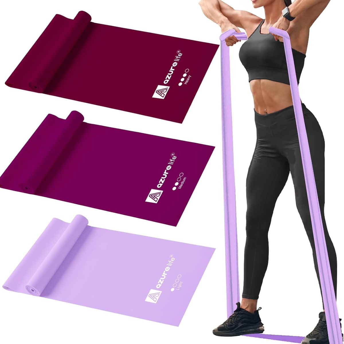 Three long flat resistance bands in shades of purple, and a woman pulling one overhead.